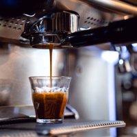 espresso drops dripping from portafilter in small coffee shop - coffee stockfoto's en -beelden