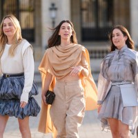 Este Haim wears white long sleeve Louis Vuitton shirt, black leather Louis Vuitton belt, dark blue puffy layered Louis Vuitton mini skirt. Danielle...