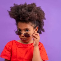 ethnic kid girl looking camera lowering sunglasses - fashion stock pictures, royalty-free photos & images