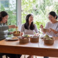 eurasian daughters and chinese mother eating vegan takeout meal together - junk food stock pictures, royalty-free photos & images