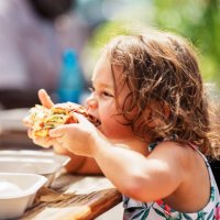 eurasian girl eating street food while vacationing in hawaii - junk food stock pictures, royalty-free photos & images