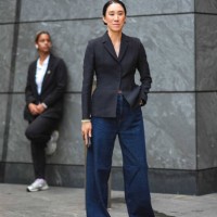Eva Chen wears a dark gray oversize blazer jacket, blue flared wide-leg denim jeans pants, ballerina shoes, outside Grace Ling, during New York...