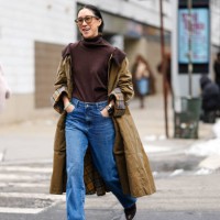 Eva Chen wears dark brown sunglasses, dark brown turtleneck sweater, olive green plaid pattern cuffed trench coat, navy blue midrise washed loose...