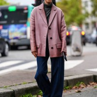 Eva Chen wears dark gray sweater, dark pink oversized blazer jacket, navy blue denim jean pants, shiny black leather boots, outside Chloe, during the...