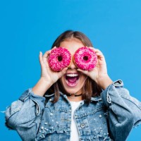 excited teenage girl covering eyes with donuts - food stock pictures, royalty-free photos & images