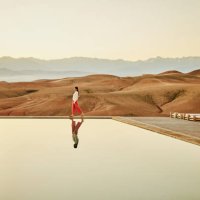 extreme wide shot woman walking poolside at luxury desert camp - travel stock pictures, royalty-free photos & images
