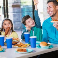 familie mit zwei kindern essen fast food - junk food stock-fotos und bilder