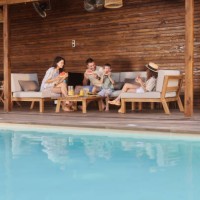 famille heureuse mangeant de la pastèque fraîche sur un patio au bord de la piscine. - garden decoration photos et images de collection