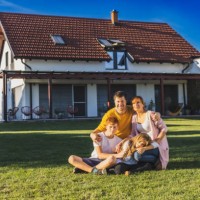 famille, homme, femme, fils et fille assis sur la pelouse dans la cour arrière de leur maison au crépuscule, regardant quelque chose au loin - garden decoration photos et images de collection