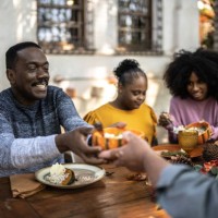 famille mangeant le déjeuner de thanksgiving à la maison - y compris les femmes ayant des besoins spéciaux - garden decoration photos et images de collection