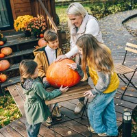 family choosing a big pumpkin for halloween decoration on a wooden porch - garden decoration stock pictures, royalty-free photos & images