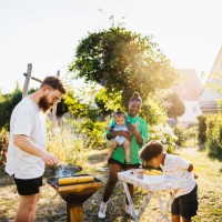 family cooking food on bbq in back garden - garden decoration photos et images de collection