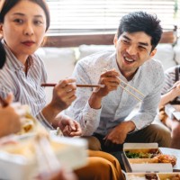 family eating takeout food in living room - junk food stock pictures, royalty-free photos & images