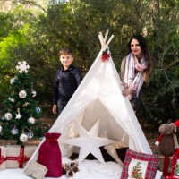 family enjoying christmas decorations next to teepee in the forest - garden decoration stock pictures, royalty-free photos & images