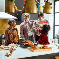family enjoying christmas dinner preparations in kitchen - home decoration stockfoto's en -beelden