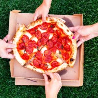 family of four sharing pizza, directly above view - junk food stock pictures, royalty-free photos & images