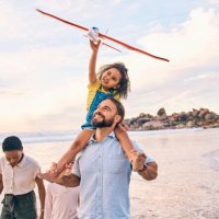 family, walking or airplane fun on sunset beach, ocean or sea in freedom holiday, energy bonding or playing game. smile, happy or children with flying toys, piggyback or interracial parents by water - travel stock pictures, r