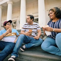family with a teenage son enjoying street food sitting on the steps - junk food stock pictures, royalty-free photos & images