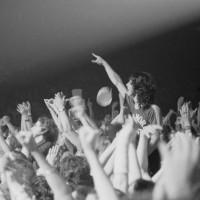 Fans and audience members watch English rock band Led Zeppelin perform live on stage on the third of three nights at Madison Square Garden, New York...