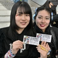 Fans of US singer Taylor Swift, also known as Swifties, pose with their tickets as people gather in front of the Tokyo Dome a few hours ahead of the...