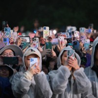 Fans record with their phones as South Korean singer Jungkook performs onstage during the Global Citizen Festival at Central Park in New York City on...