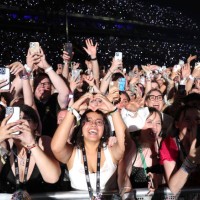 Fans watch Taylor Swift perform onstage during night two of "Taylor Swift | The Eras Tour" at La Defense on May 10, 2024 in Paris, France.