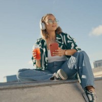 fashion, music and woman with phone in city listening to audio, radio and track in skate park. headphones, summer and female person relax outdoors on smartphone for social media, online and internet - fashion stock pictures, 
