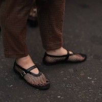 Fashion Show Guest was seen wearing brown and green ckecked trousers and black shoes with a black net on it before the Huishan Zhang Fashion Show...