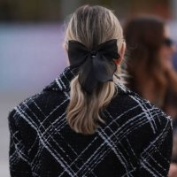 Fashion week guest is seen wearing a black and white checked jacket with a black ribbon in her hair during the Chanel Show Womenswear Spring/Summer...