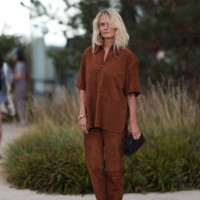 Fashion Week guest is seen wearing a brown suede matching two-piece, consisting of a short-sleeved top with half-zip and collar, and long...