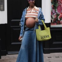 Fashion week guest is seen wearing a crop top with red and orange stripes and collar by Miu Miu with a blue denim jacket, a long denim skirt, black...
