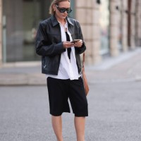 Fashion Week guest is seen wearing havana-framed sunglasses with wide temples and blue lenses from Tom Ford Bronson, golden round earrings, a black...