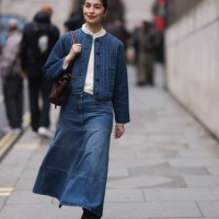 Fashion Week Guest seen wearing a blue denim long skirt, white shirt, blue jacket, brown leather handbag, black leather boots outside Charlie...