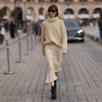 Fashion Week Guest was seen wearing black heels, a beige longsleeve with turtle-neck as well as a matching light beige skirt and dark shades before...