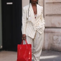 Fashion Week guest was seen wearing red socks and a red bag, yellow gold earrings, beige shades as well as a white bra, yellow gold shoes with...