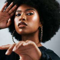 fashionable afro cover model with fierce, powerful attitude and funky, trendy hairstyle. powerful portrait of intense, retro and melanin woman against studio background in stylish fashion accessories - fashion stock pictures,
