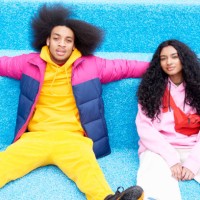 fashionable couple sitting on blue floor - fashion stock pictures, royalty-free photos & images