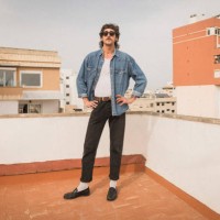 fashionable man standing with arms akimbo on building terrace - fashion stock pictures, royalty-free photos & images