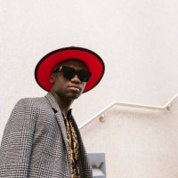 fashionable man wearing hat and sunglasses standing in front of wall - fashion photos et images de collection