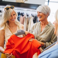 fashionable mature women shopping for clothes in fashion boutique - fashion stock pictures, royalty-free photos & images