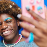 fashionable, quirky person standing in front of a photo booth style blue curtain. - hairstyle stock pictures, royalty-free photos & images