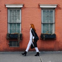 fashionable redhead woman walking by the brick wall building in west village, manhattan, ny - fashion stock pictures, royalty-free photos & images