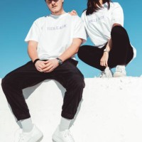 fashionable young couple sitting on concrete wall modern fashion portrait - fashion stock pictures, royalty-free photos & images