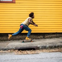 fashionable young man skateboarding in front of yellow urban home - fashion stock pictures, royalty-free photos & images