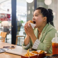 fat asian business women happy hamburgers in fast food restaurants - junk food stock pictures, royalty-free photos & images