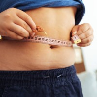 fat boy measuring his belly - junk food stock pictures, royalty-free photos & images