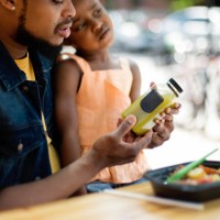 father and daughter eating take out food outdoors. - junk food stock pictures, royalty-free photos & images