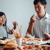 father and daughter sharing pizza together at home - junk food stock pictures, royalty-free photos & images