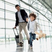 father and son (5-6) running across airport lobby - travel stock pictures, royalty-free photos & images