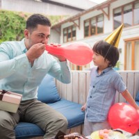 father and son blowing balloon - garden decoration stock pictures, royalty-free photos & images